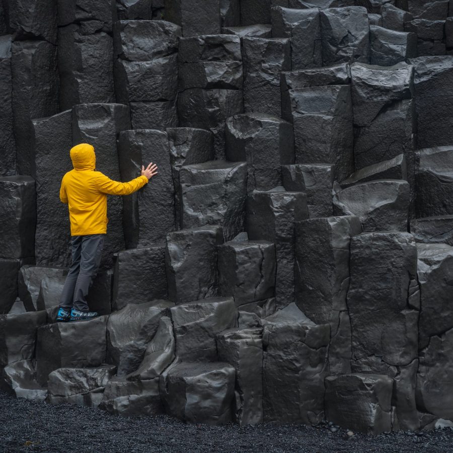 Adult,Man,In,Yellow,Jacket,Standing,On,Basalt,Columns,On